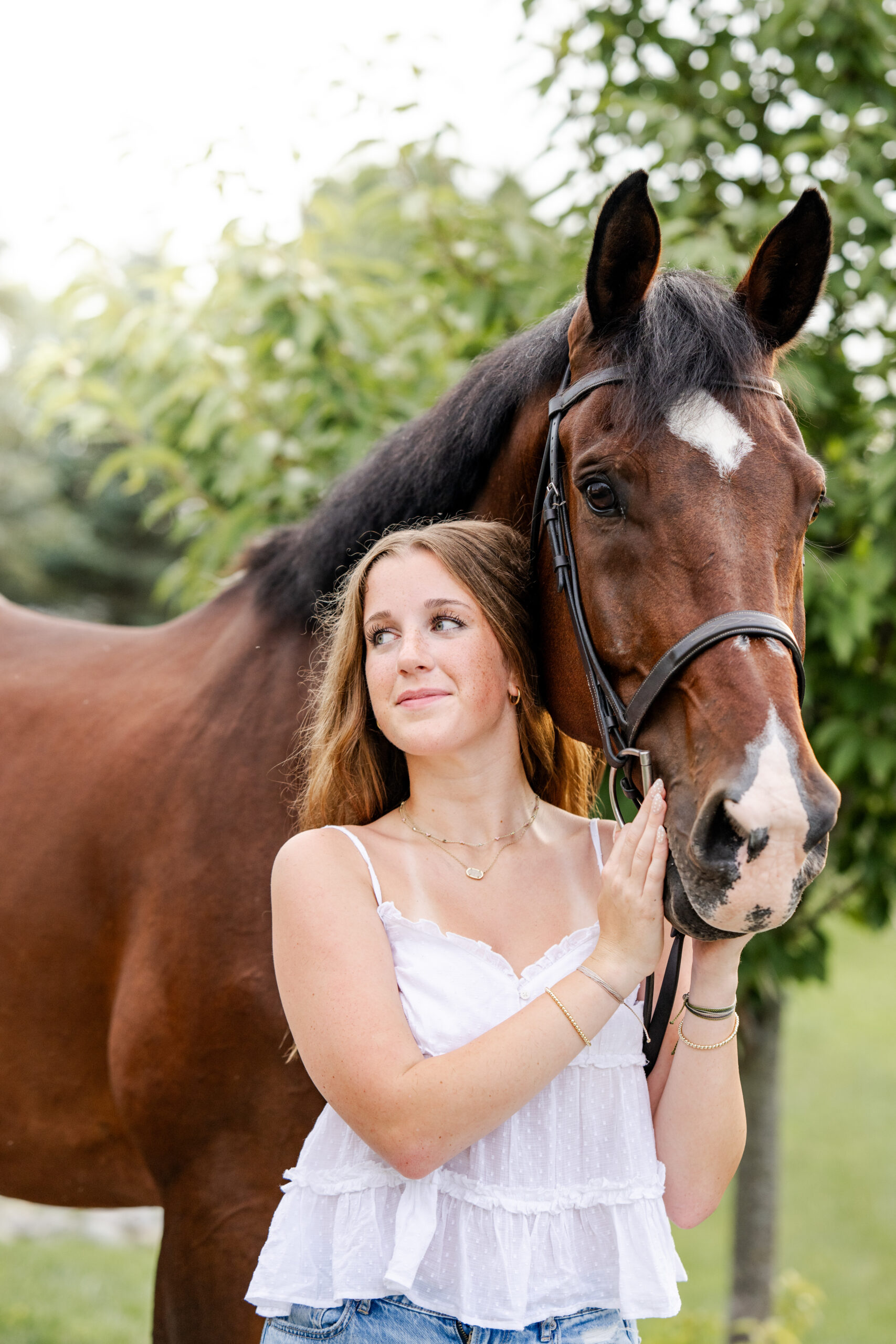 Carmel, Indiana equestrian senior poses with her horse during golden hour portraits by Kate Kosnoff Creative